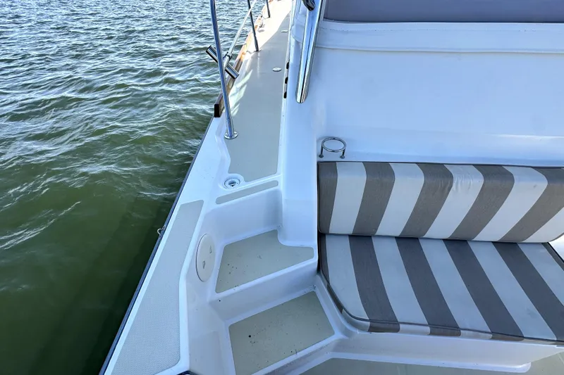 Destiny Yacht Photos Pics 2007 Sabre 34 Express boat with striped seating, docked on calm water.