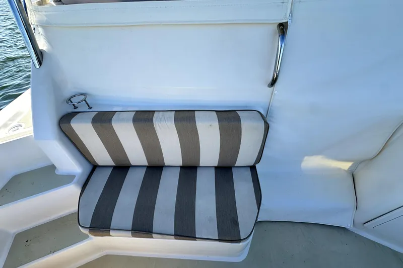 Destiny Yacht Photos Pics Striped seat on 2007 Sabre 34 Express boat, featuring a cup holder and railing.