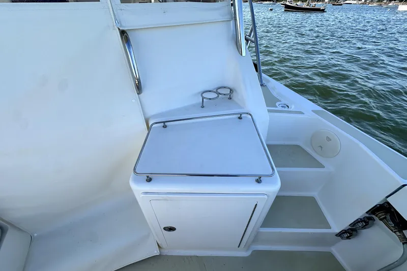 Destiny Yacht Photos Pics 2007 Sabre 34 Express boat deck with storage compartment and cup holders by the water.