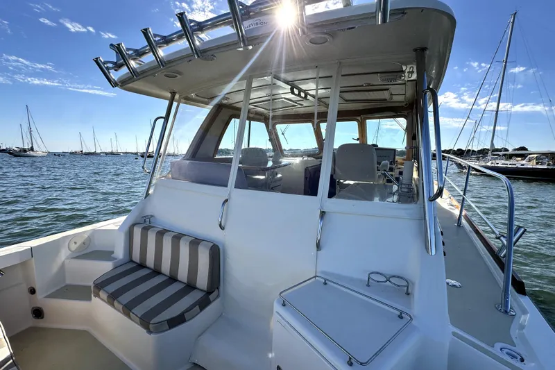 Destiny Yacht Photos Pics 2007 Sabre 34 Express boat on water, featuring a sunlit deck and striped seating.