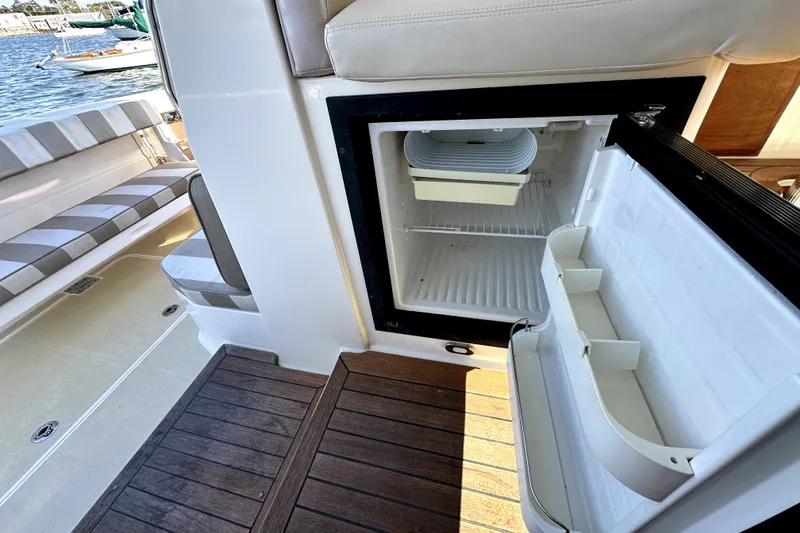 Destiny Yacht Photos Pics Open fridge on 2007 Sabre 34 Express boat, with wooden deck and seating area.