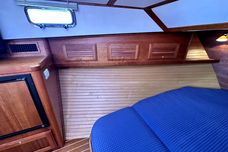 Destiny Yacht Photos Pics 2007 Sabre 34 Express cabin interior with wood paneling and blue bedding.