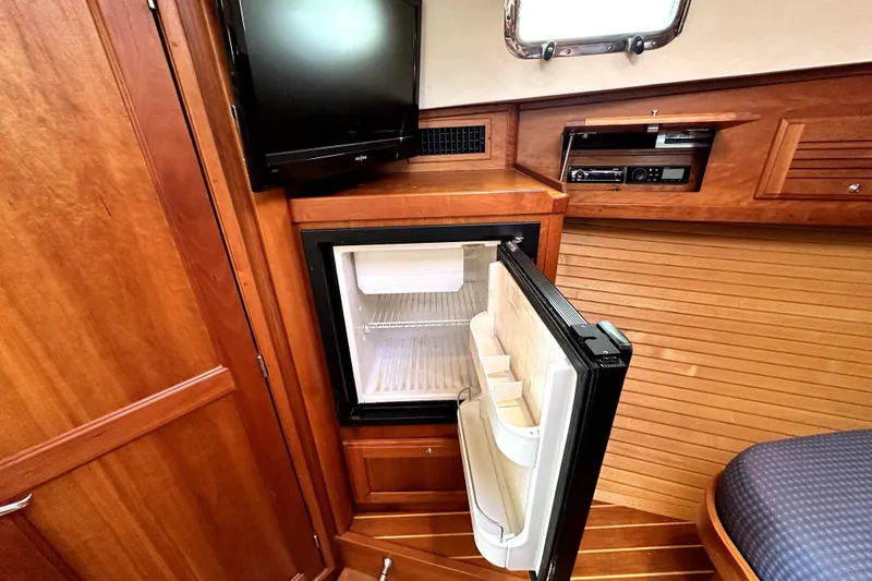 Destiny Yacht Photos Pics 2007 Sabre 34 Express interior with open fridge, TV, and wooden cabinetry.