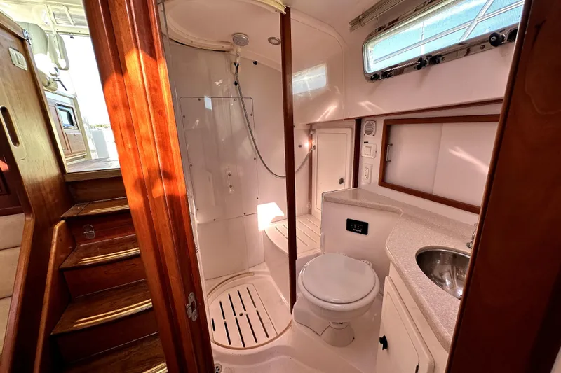 Destiny Yacht Photos Pics 2007 Sabre 34 Express yacht bathroom with shower, toilet, sink, and wooden accents.