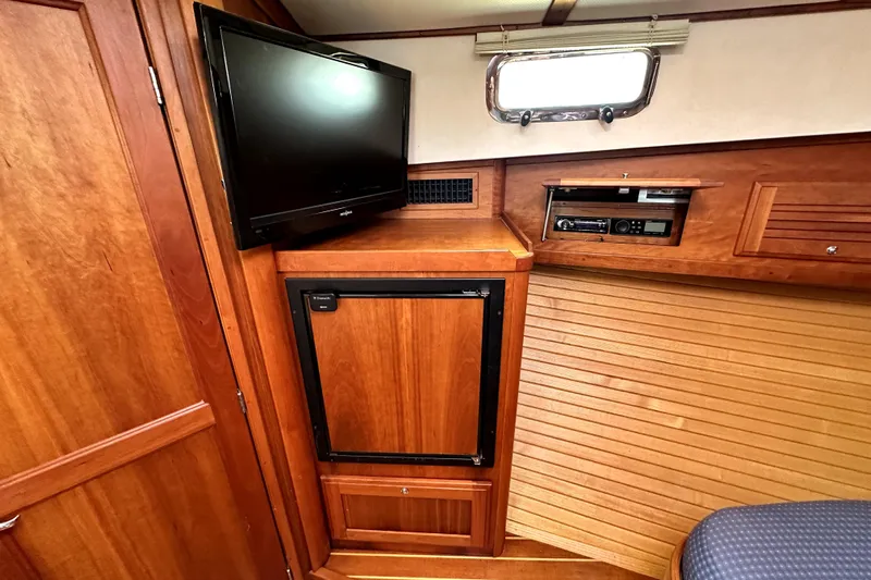 Destiny Yacht Photos Pics 2007 Sabre 34 Express cabin interior with TV, wooden cabinetry, and window.