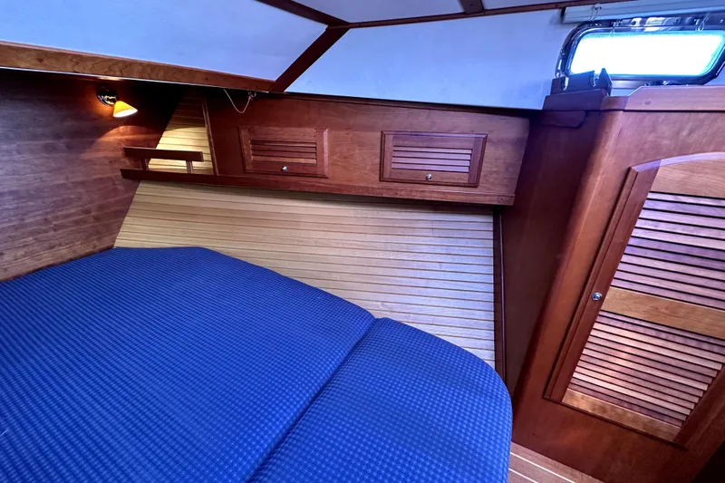 Destiny Yacht Photos Pics 2007 Sabre 34 Express cabin interior with wooden finish and blue bedding.