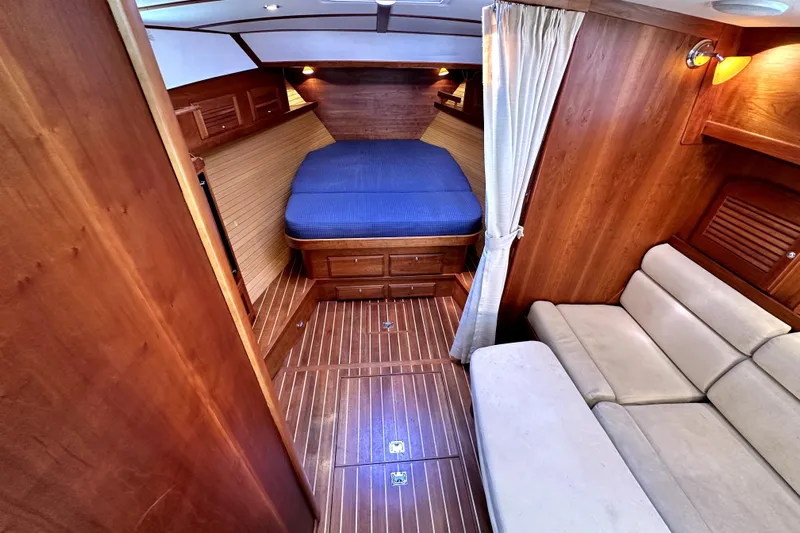 Destiny Yacht Photos Pics 2007 Sabre 34 Express cabin with wood interior, blue bedding, and beige sofa.