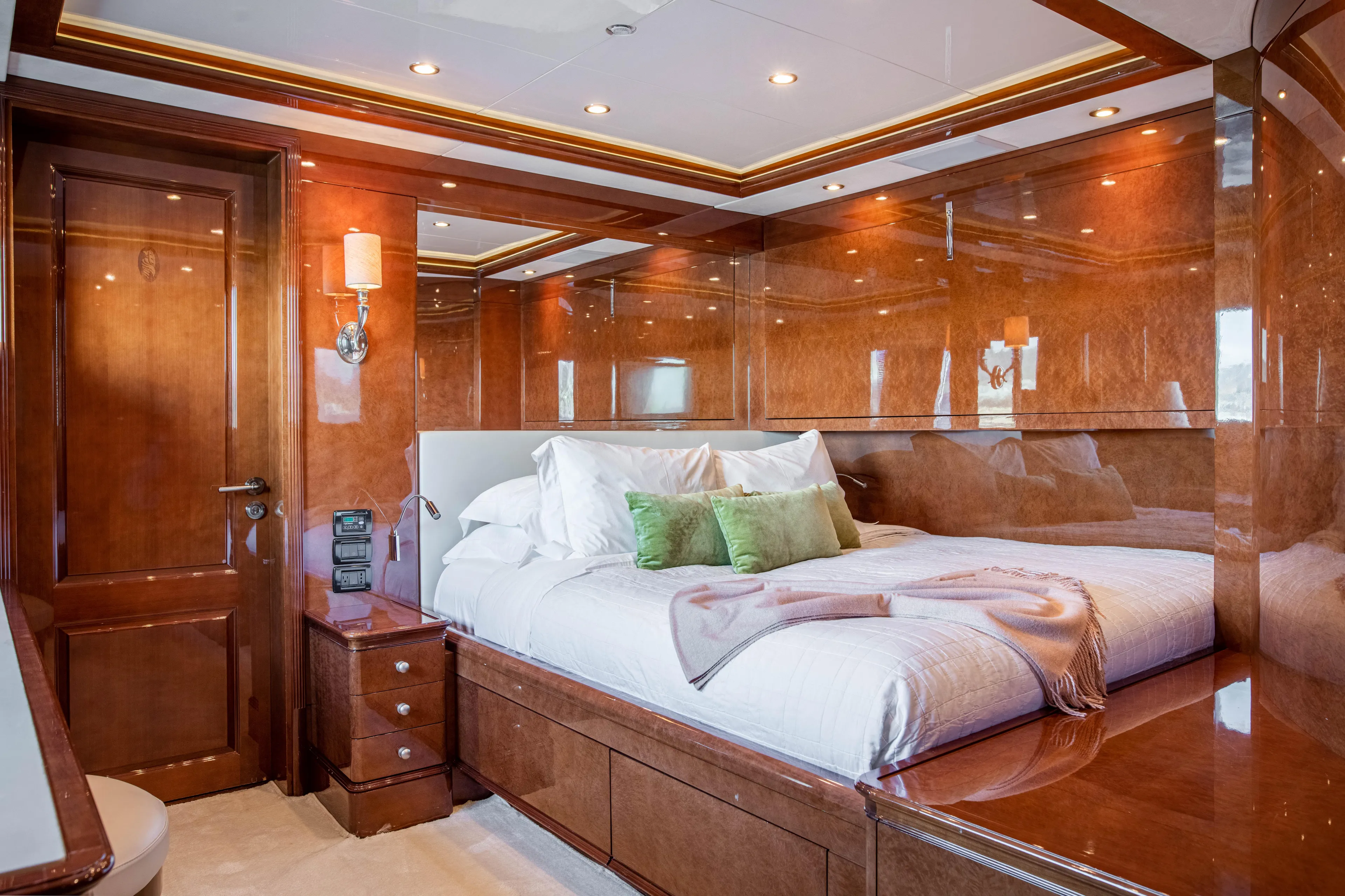 Checkmate Yacht Photos Pics Luxurious bedroom interior on 2013 Benetti 44 yacht, featuring polished wood and elegant bedding.