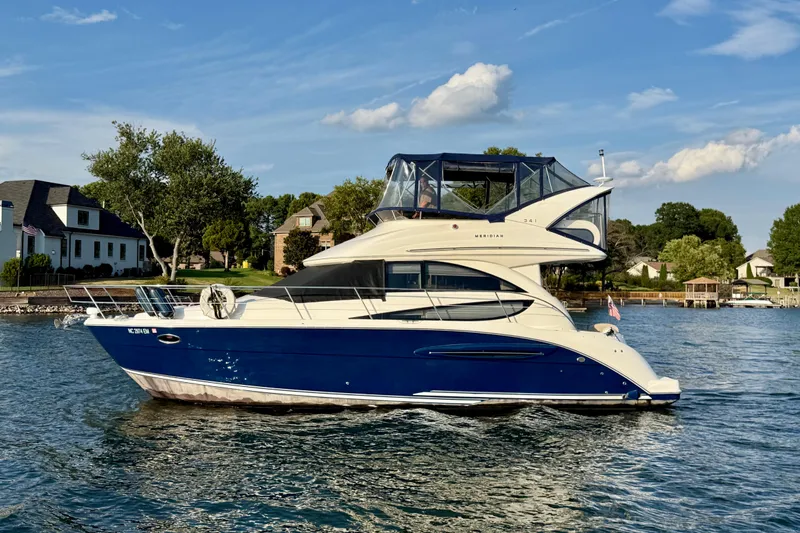 Freshwater Boat- New Trade-in- Obo Yacht Photos Pics 2011 Meridian 341 Sedan yacht on a serene lake with houses in the background.
