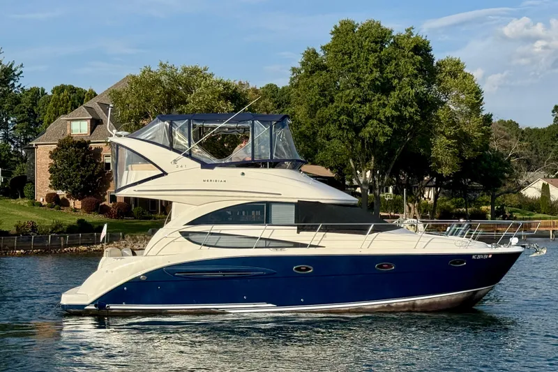Freshwater Boat- New Trade-in- Obo Yacht Photos Pics 2011 Meridian 341 Sedan yacht cruising on a serene lake near a residential area.