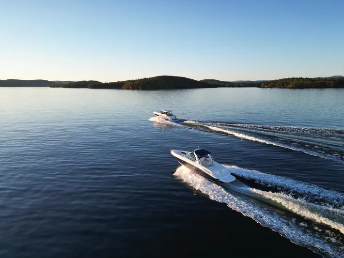  Yacht Photos Pics 2015 Sea Ray 300 SLX boats cruising on a serene lake at sunset.