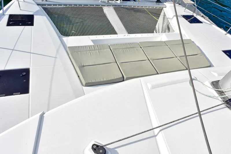 Boomerang Yacht Photos Pics Deck of 2022 Fountaine Pajot Astrea 42 catamaran with cushioned seating and netting.