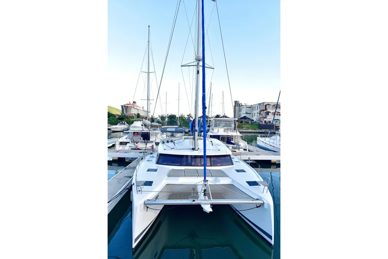Boomerang Yacht Photos Pics 2022 Fountaine Pajot Astrea 42 catamaran docked in a marina, front view.