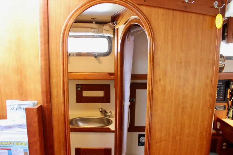 Mangata Yacht Photos Pics Interior of a 1997 Valiant 39 sailboat featuring a wooden bathroom with a sink.