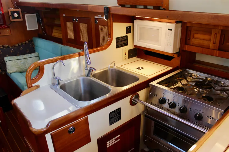 Mangata Yacht Photos Pics 1997 Valiant 39 yacht kitchen with dual sinks, stove, and microwave.