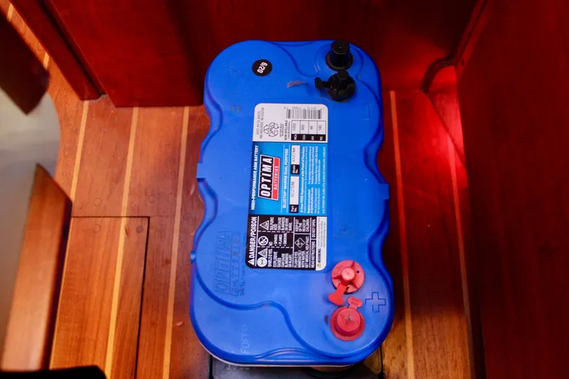 Mangata Yacht Photos Pics Blue Optima battery inside a 1997 Valiant 39 boat, placed on wooden flooring.