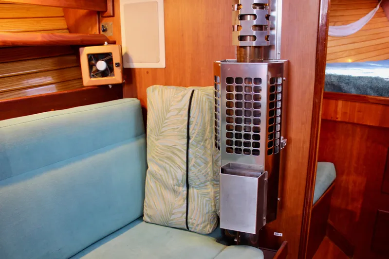 Mangata Yacht Photos Pics Cozy interior of a 1997 Valiant 39 sailboat with seating and a stainless steel heater.