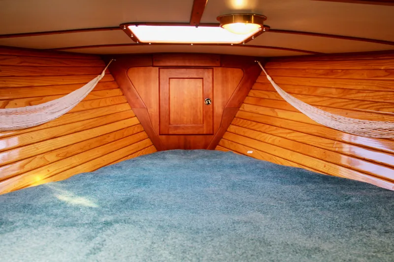 Mangata Yacht Photos Pics Cozy interior of 1997 Valiant 39 sailboat with wood paneling and blue carpet.