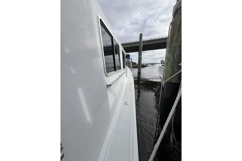 Yacht Photos Pics 2006 Provincial 42 Lobster Boat docked beside a pier under cloudy skies.