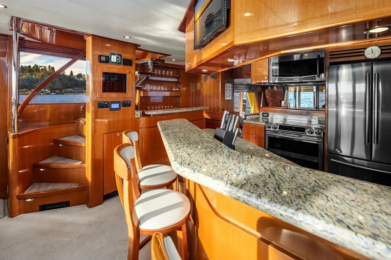 La Bella Vita II Yacht Photos Pics Luxurious 2014 Hampton 720 Skylounge LRC yacht interior with modern kitchen and elegant wood finishes.