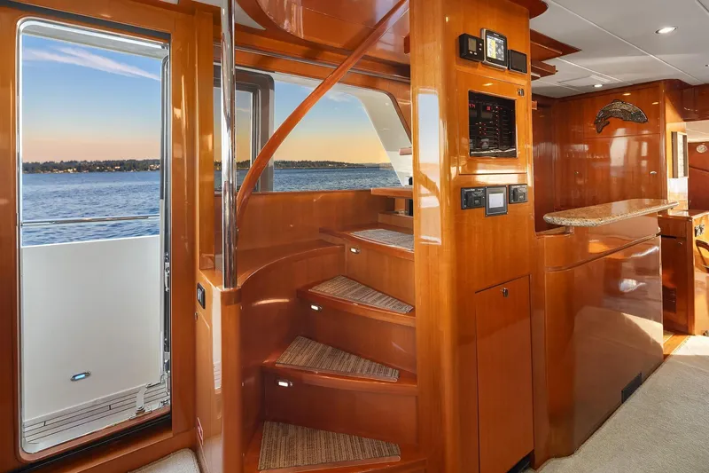 La Bella Vita II Yacht Photos Pics Luxurious interior of 2014 Hampton 720 Skylounge LRC yacht with wooden staircase and ocean view.