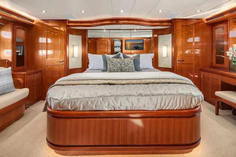 La Bella Vita II Yacht Photos Pics Luxurious bedroom interior of 2014 Hampton 720 Skylounge LRC yacht with elegant wood finishes.