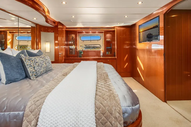 La Bella Vita II Yacht Photos Pics Luxurious bedroom interior of 2014 Hampton 720 Skylounge LRC yacht with elegant wood finishes.