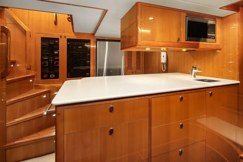 La Bella Vita II Yacht Photos Pics Luxurious 2014 Hampton 720 Skylounge LRC yacht interior with modern kitchen and wooden cabinetry.