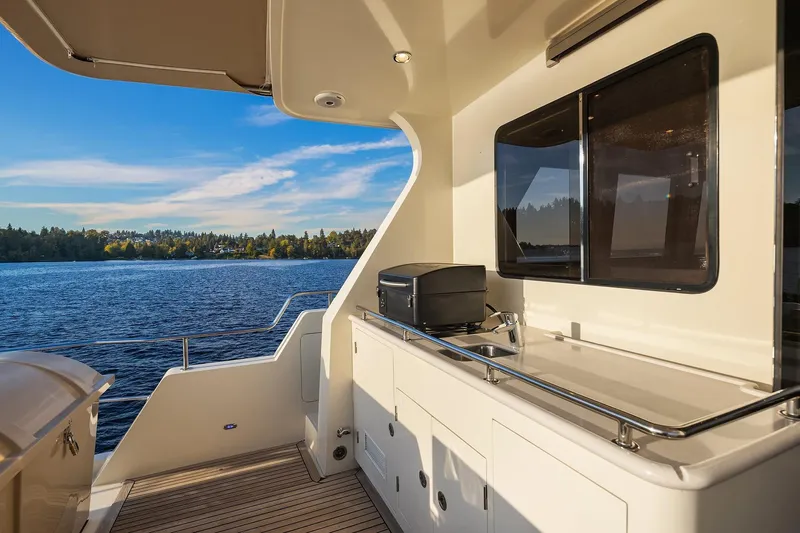 La Bella Vita II Yacht Photos Pics 2014 Hampton 720 Skylounge LRC yacht deck with sink, overlooking serene lake and forest.