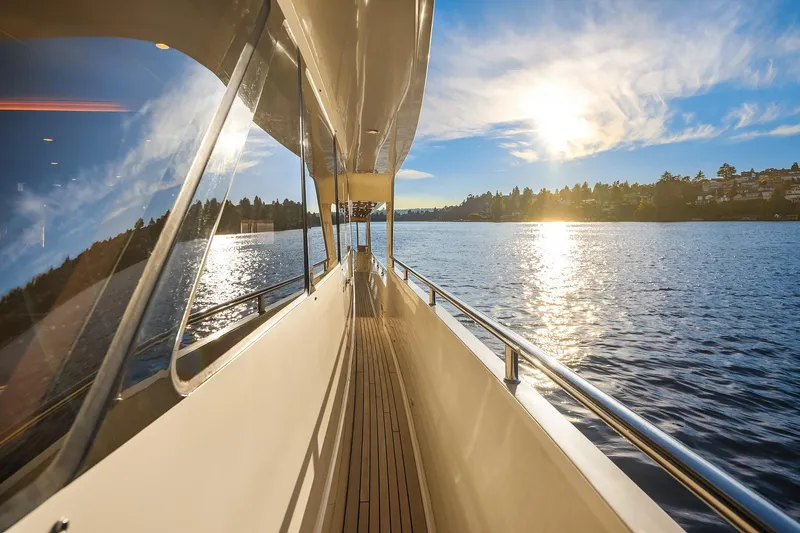 La Bella Vita II Yacht Photos Pics 2014 Hampton 720 Skylounge LRC yacht cruising on a sunny day, reflecting on calm waters.