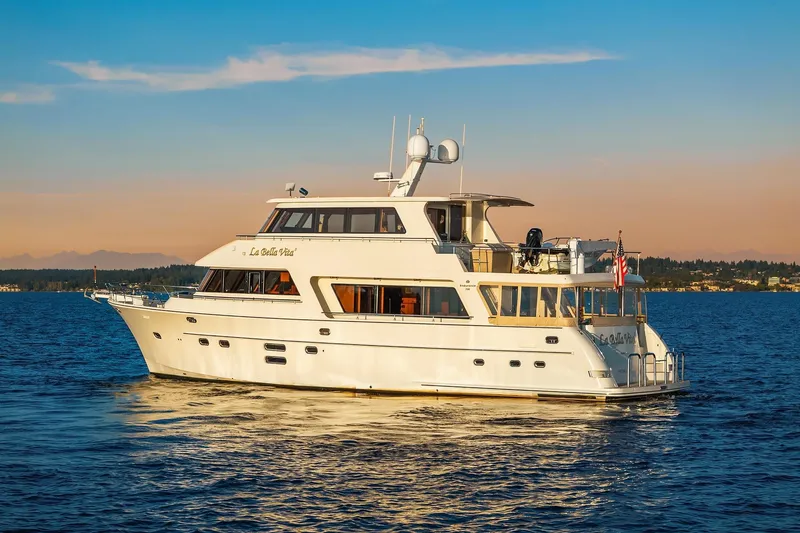 La Bella Vita II Yacht Photos Pics 2014 Hampton 720 Skylounge LRC yacht cruising on serene waters at sunset.