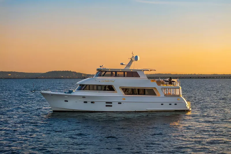 La Bella Vita II Yacht Photos Pics 2014 Hampton 720 Skylounge LRC yacht cruising at sunset on calm waters.