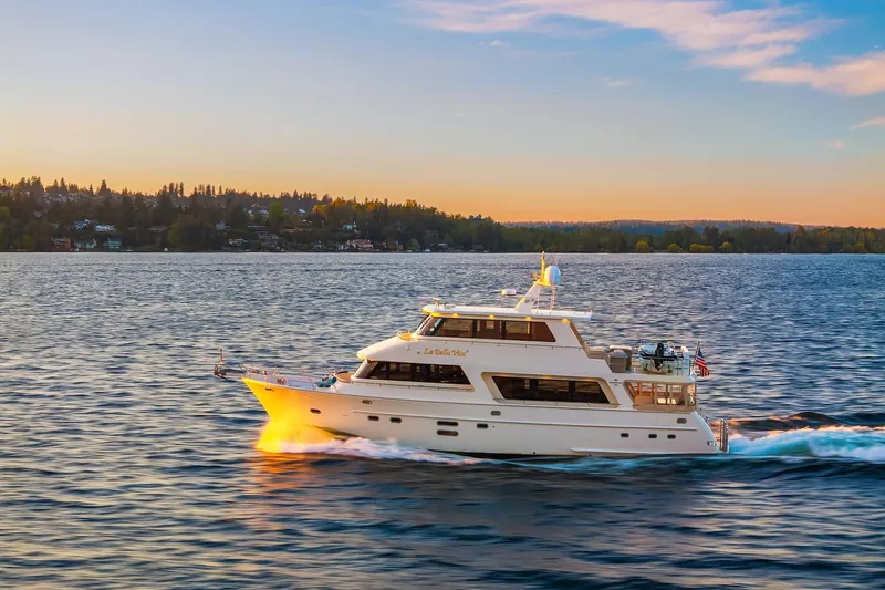 La Bella Vita II Yacht Photos Pics Luxurious 2014 Hampton 720 Skylounge LRC yacht cruising at sunset on serene waters.