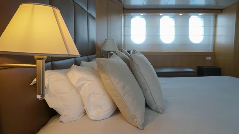 Petrus 2007 Sl108 @livorno Italy Yacht Photos Pics Luxurious bedroom interior on 2007 Sanlorenzo 108 yacht with elegant lighting and plush pillows.