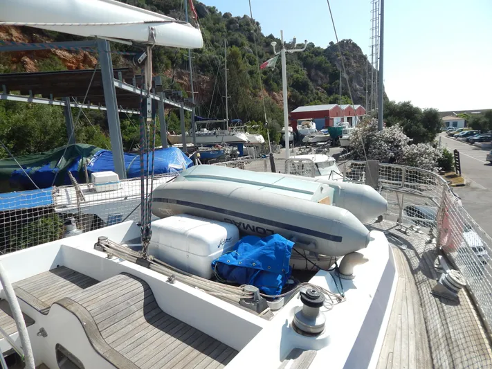  Yacht Photos Pics Tayana 55 sailboat deck with inflatable dinghy, docked near lush hillside, 1992 model.