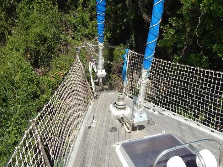  Yacht Photos Pics Deck of 1992 Tayana 55 sailboat with blue-wrapped masts and lush greenery.