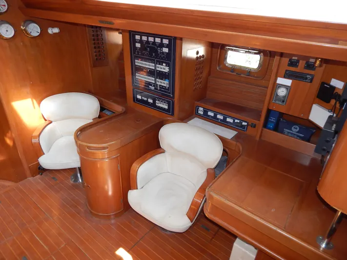  Yacht Photos Pics Interior of 1992 Tayana 55 yacht with wooden paneling and white cushioned chairs.