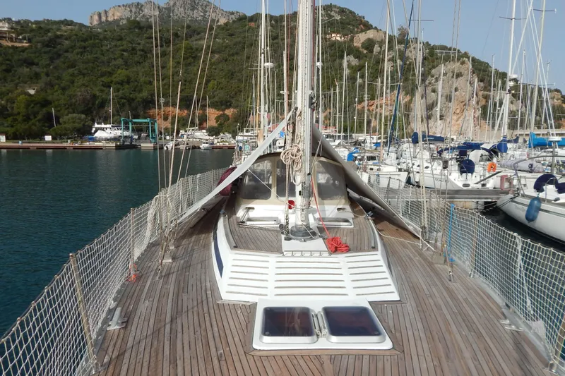  Yacht Photos Pics Sailboat Tayana 55, 1992 model, docked in a scenic marina with lush hills.