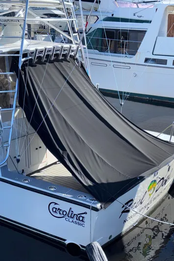 Reel Deal Yacht Photos Pics 2001 Carolina Classic 35 boat with black cover docked in marina.