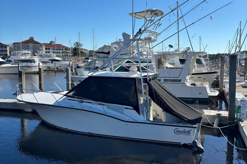 Reel Deal Yacht Photos Pics 2001 Carolina Classic 35 boat docked in marina, clear sky, calm water.