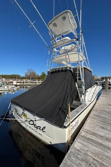 Reel Deal Yacht Photos Pics 2001 Carolina Classic 35 boat docked, featuring a tower and black canvas cover.
