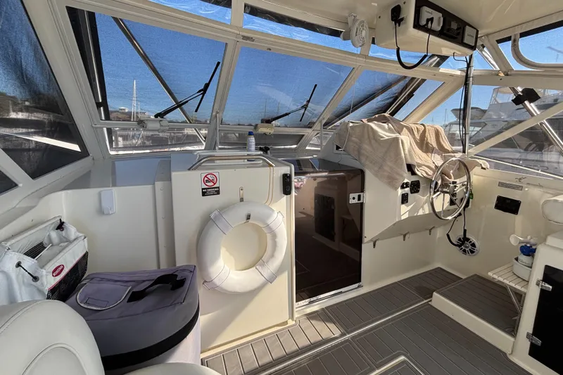 Reel Deal Yacht Photos Pics Interior view of 2001 Carolina Classic 35 boat cockpit with steering wheel and life preserver.