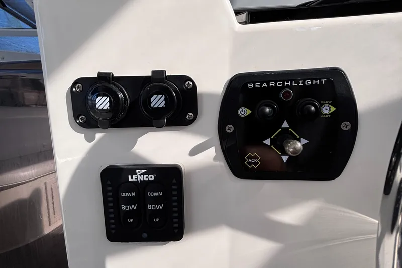 Reel Deal Yacht Photos Pics Control panel of a 2001 Carolina Classic 35 boat with searchlight and Lenco trim tab switches.