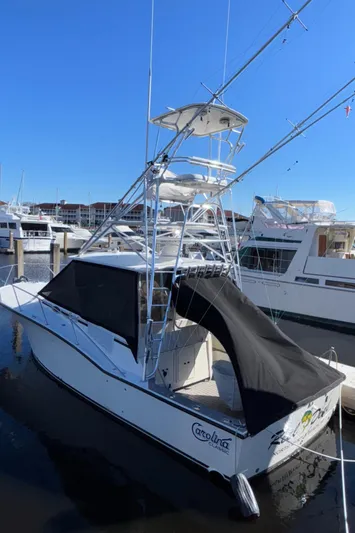 Reel Deal Yacht Photos Pics 2001 Carolina Classic 35 boat docked at marina, featuring a tower and black canopy.