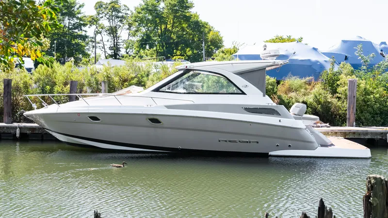  Yacht Photos Pics 2012 Regal 35 Sport Coupe boat docked in a serene marina setting.