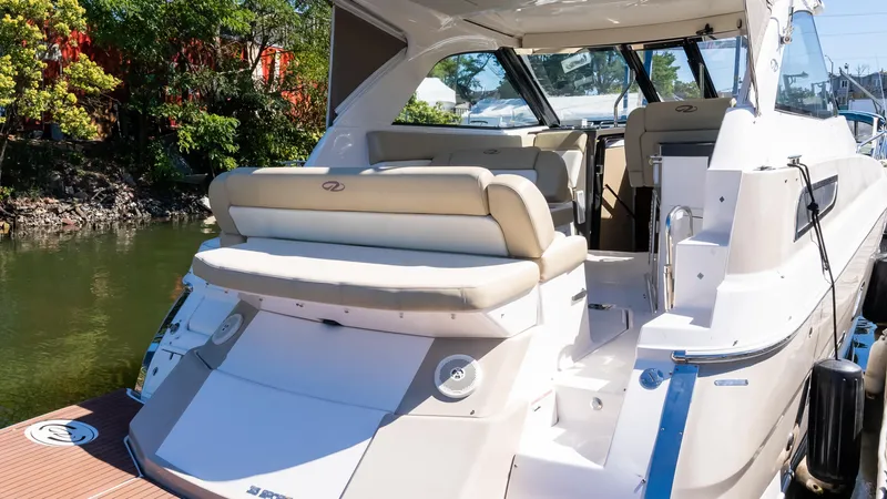  Yacht Photos Pics 2012 Regal 35 Sport Coupe yacht with spacious seating, docked by lush greenery.