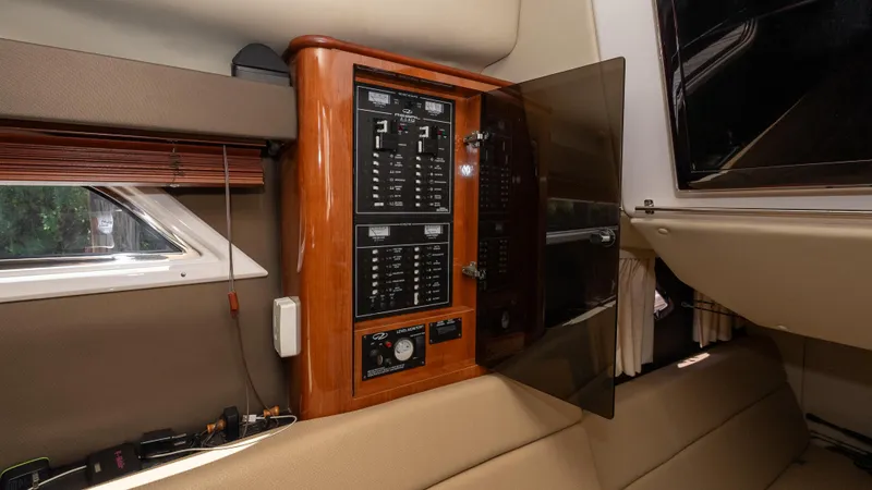  Yacht Photos Pics Electrical panel inside 2012 Regal 35 Sport Coupe boat cabin, featuring wood finish and modern controls.