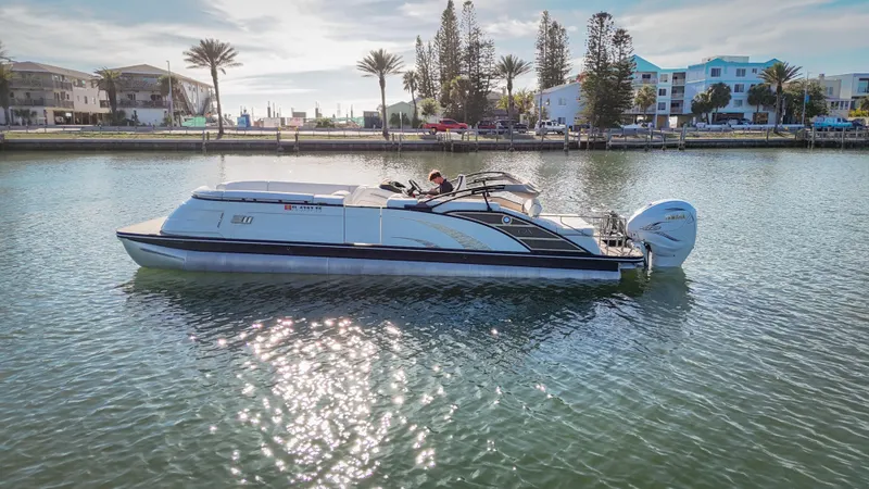  Yacht Photos Pics 2021 Bennington 27 QX boat cruising on a sunny waterfront with palm trees and buildings.