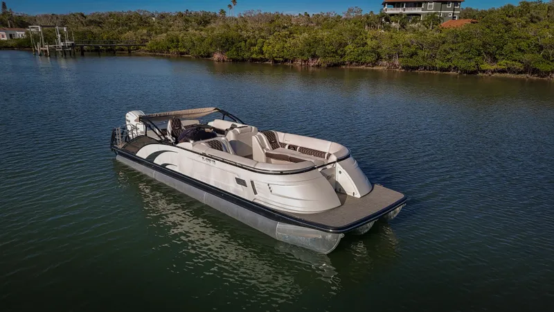  Yacht Photos Pics 2021 Bennington 27 QX pontoon boat on calm water, surrounded by lush greenery.