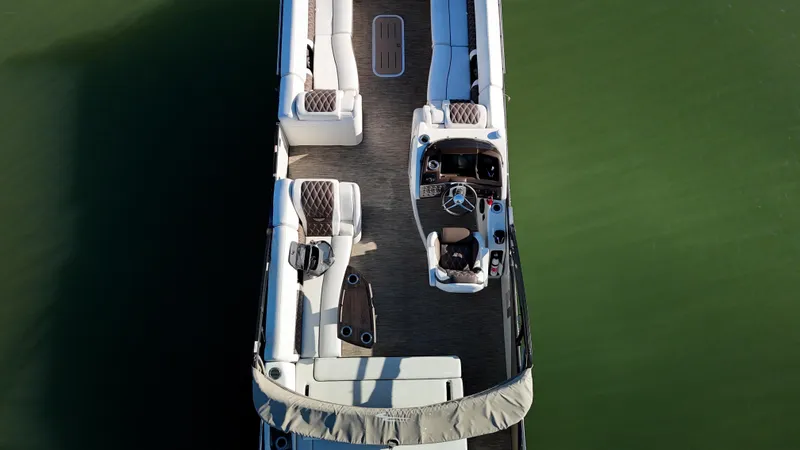  Yacht Photos Pics Aerial view of 2021 Bennington 27 QX pontoon boat on calm water.